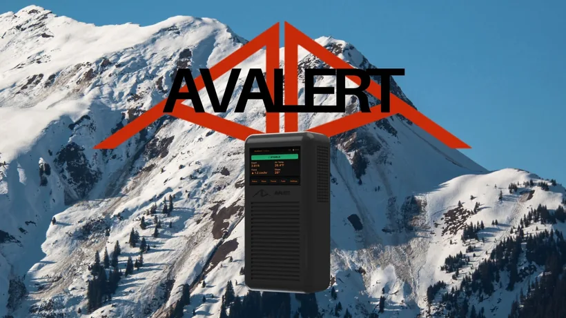 The AvAlert handheld device in front of snowy mountain peaks with the AvAlert logo